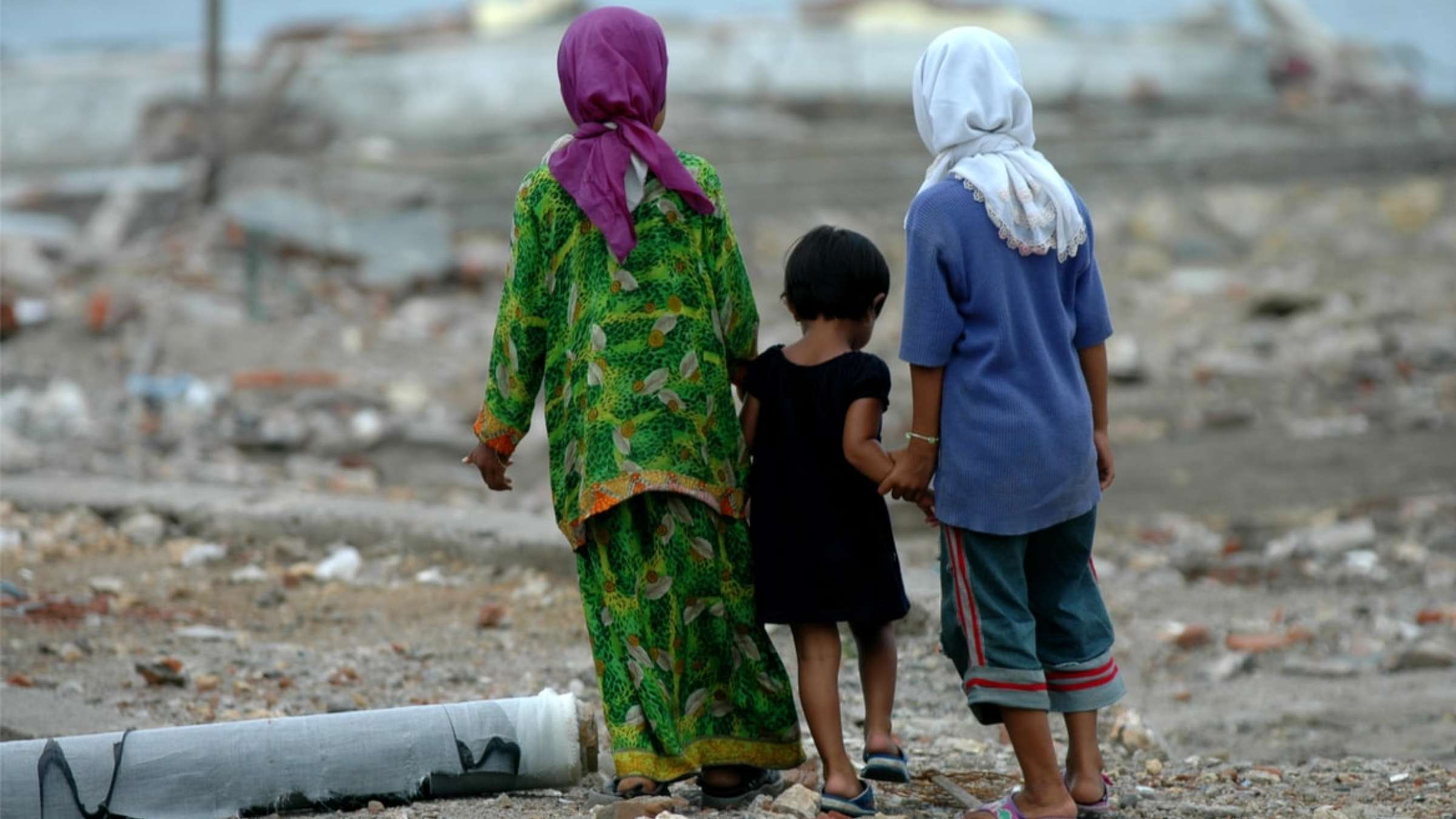 Three girls walking on the site of the 2004 Indonesia tsunami