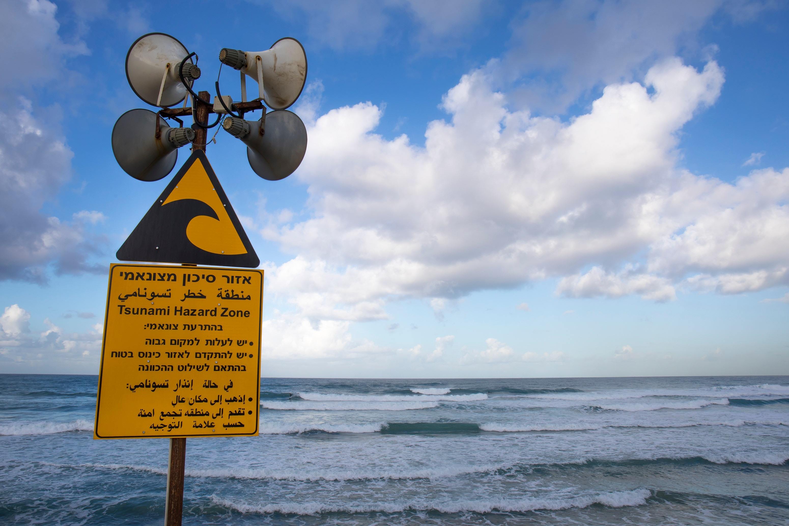 a hazard sign on a beach in Tel Aviv with sirens to facilitate early warnings systems