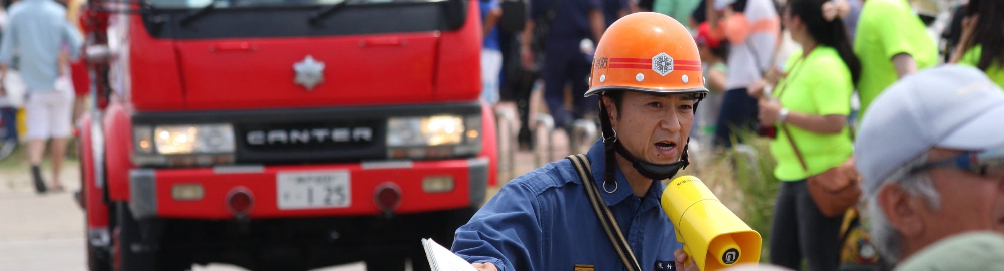 During a tsunami evacuation drill held at a beach, firefighters urge people to evacuate from the coast, in Hyogo, Japan, 2013.