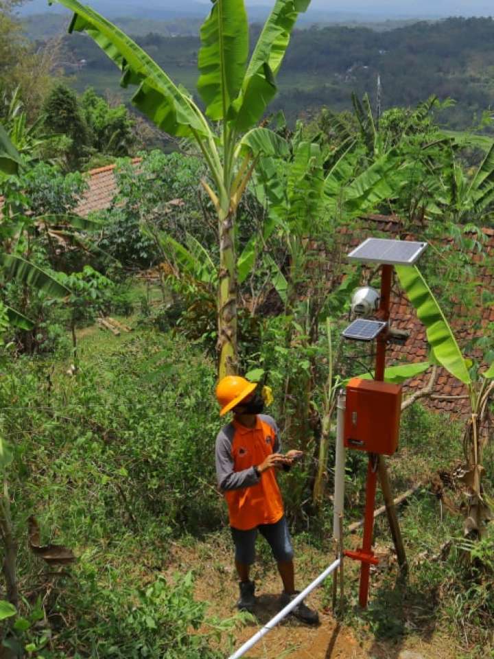 officer checking the condition of the solar panel, early warning system, in anticipation of landslides